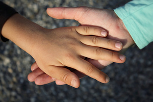 Kinderhand auf Hand von Erwachsenen